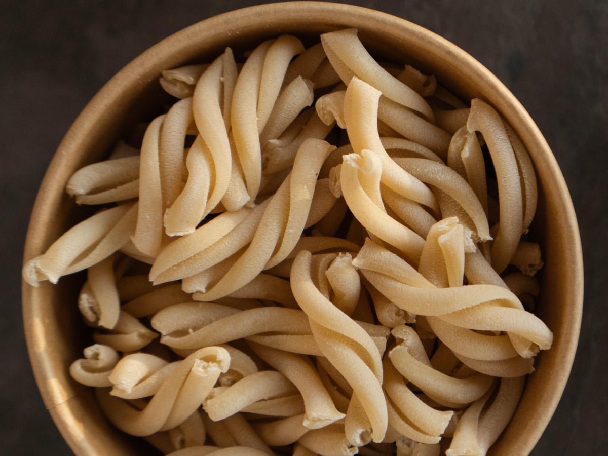 Casarecce — hand-rolled twisted pasta scrolls in a wooden bowl